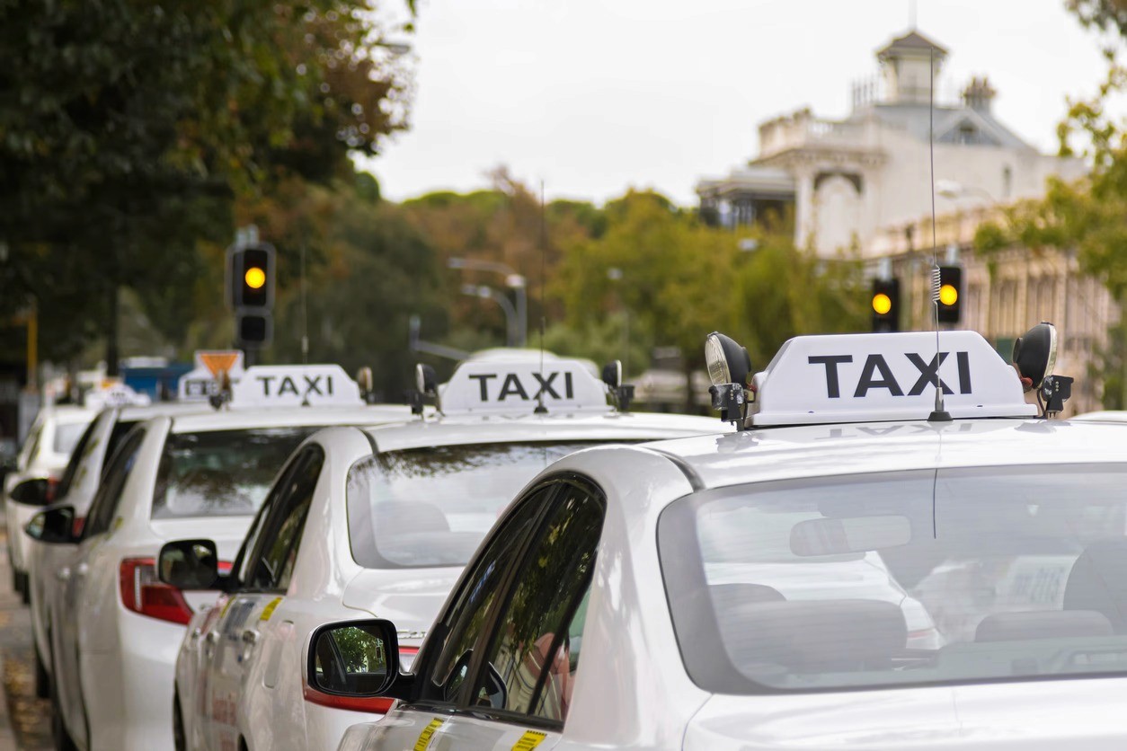 taxi car between brown buildings during day time